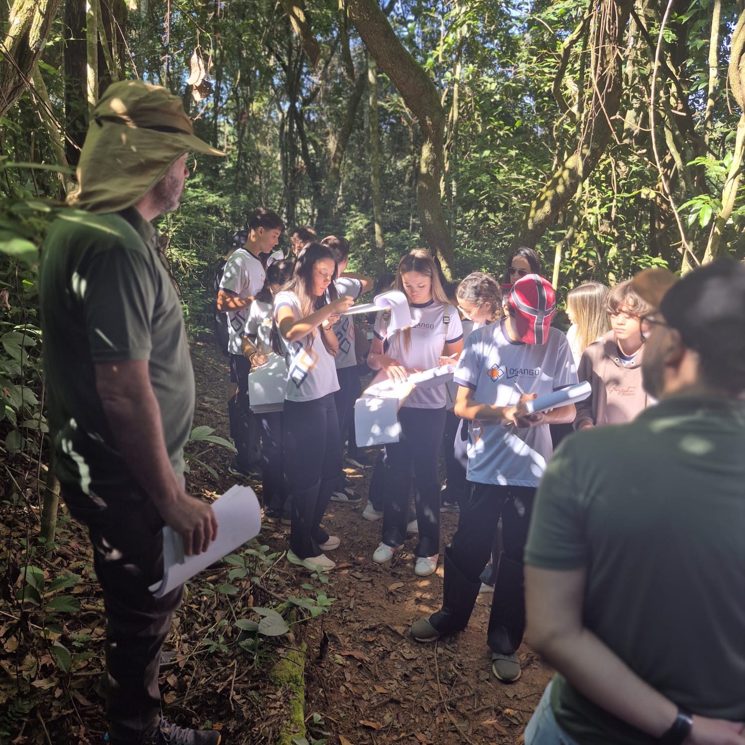 Turma escolar conduzida pela equipe técnica na trilha do Centro Ambiental Cedro
